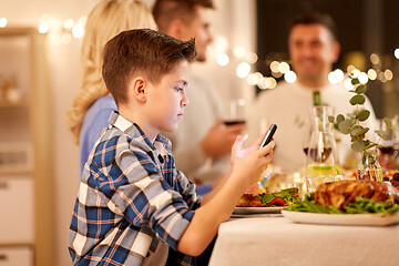 Image showing boy with smartphone at family dinner party