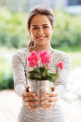 Image showing young woman with cyclamen flowers at summer garden