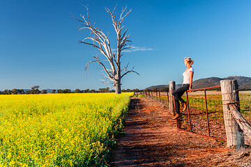 Image showing Country woman basking in the spring sunshine looking out over th