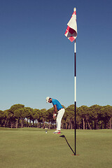 Image showing golf player hitting shot at sunny day