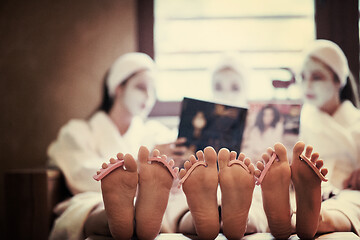 Image showing bachelorette party in spa, girls with face mask reading magazine