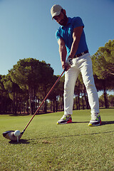 Image showing golf player placing ball on tee