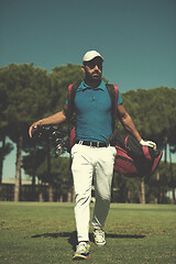 Image showing golf player walking and carrying bag