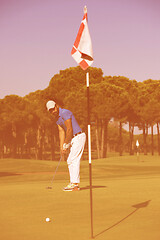 Image showing golf player hitting shot at sunny day