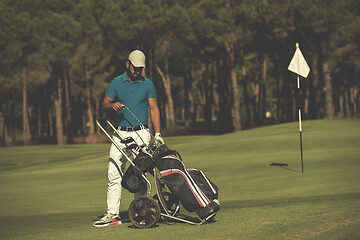 Image showing golf player walking with wheel bag