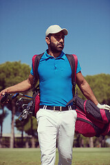 Image showing golf player walking and carrying bag