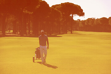 Image showing golf player walking with wheel bag