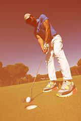 Image showing golf player hitting shot at sunny day, wide angle lens