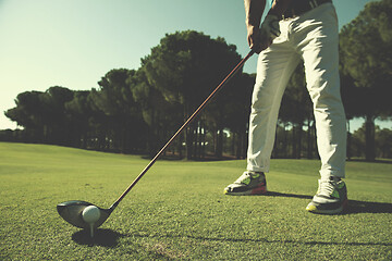 Image showing golf player placing ball on tee