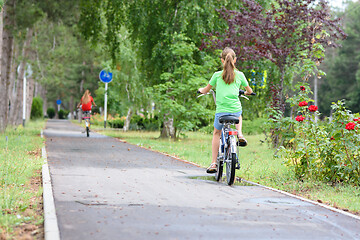 Image showing Girl rides on a special bike path in a city park