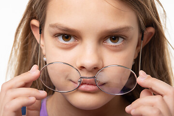 Image showing Closeup portrait of a girl who took off round glasses