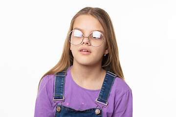 Image showing Portrait of a girl in glare glasses trying to look at her nose