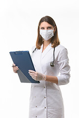 Image showing Portrait of a doctor girl in a medical mask and gloves