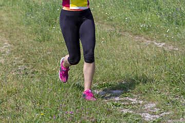 Image showing Young woman running in nature on a rural road 