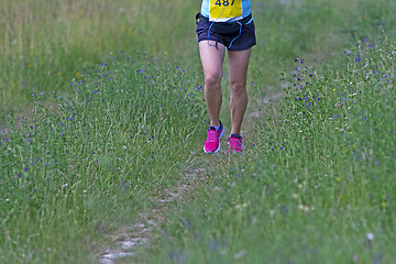 Image showing Young woman running in nature on a rural road 