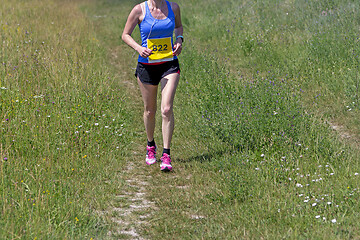 Image showing Young woman running in nature on a rural road 