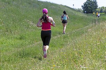 Image showing Young women running in nature on a rural road 