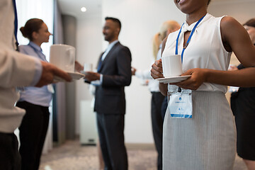 Image showing business people with conference badges and coffee