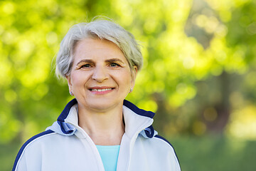 Image showing smiling sporty senior woman at summer park