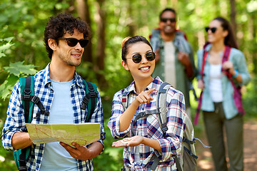 Image showing friends with map and backpacks hiking in forest