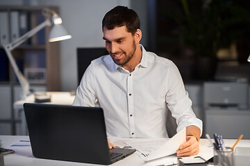 Image showing businessman with laptop working at night office