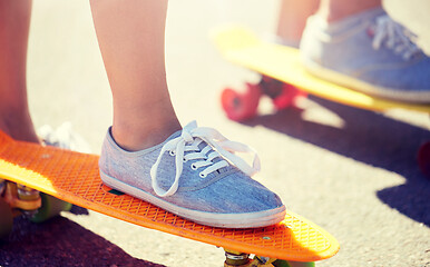 Image showing close up of feet riding skateboards on city street