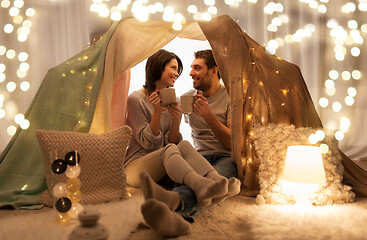 Image showing couple drinking coffee or tea in kids tent at home