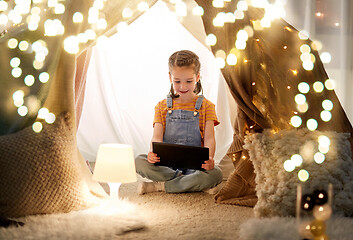 Image showing little girl with tablet pc in kids tent at home