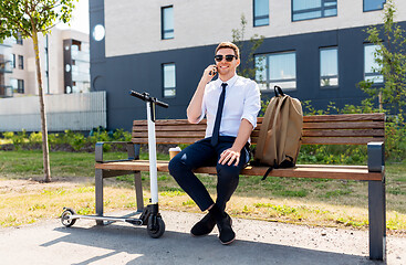 Image showing businessman with scooter calling on smartphone