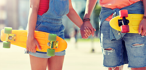 Image showing close up of young couple with skateboards in city