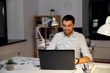 Image showing businessman with laptop working at night office