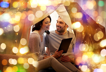 Image showing happy couple with tablet pc in kids tent at home