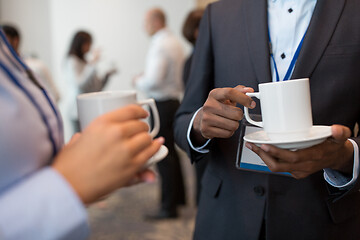 Image showing business people with conference badges and coffee