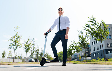 Image showing young businessman riding electric scooter outdoors