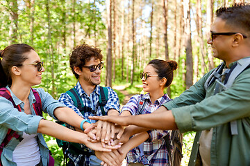 Image showing friends with backpacks stacking hands in forest