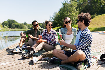 Image showing friends drinking beer and cider on lake pier