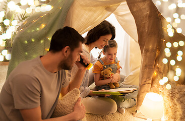 Image showing happy family reading book in kids tent at home