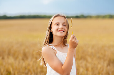 Image showing girl with spikelet of wheat on cereal field