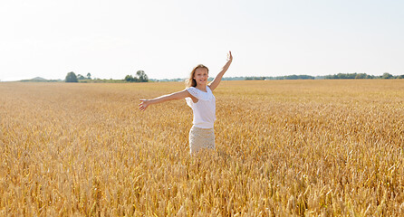 Image showing happy smiling young girl on cereal field in summer