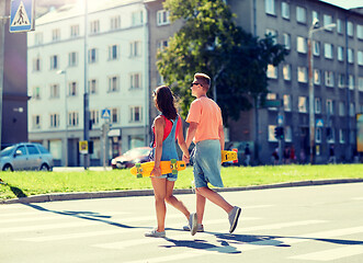 Image showing teenage couple with skateboards on city crosswalk