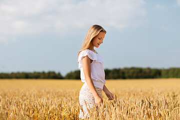 Image showing smiling young girl on cereal field in summer