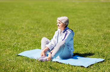 Image showing happy senior woman exercising at summer park