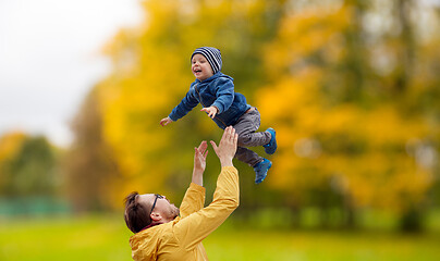 Image showing father with son playing and having fun in autumn