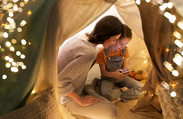 Image showing happy family with smartphone in kids tent at home