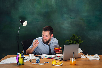 Image showing Ill young man with fever and cold looks suffering at home