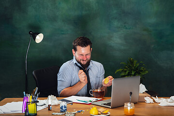 Image showing Ill young man with fever and cold looks suffering at home