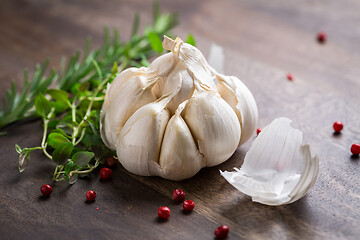 Image showing Garlic with red pepper and herbs on wooden background