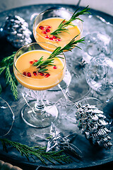 Image showing Traditional egg liqueur or eggnog with cinnamon, pomegranate and rosemary for Christmas