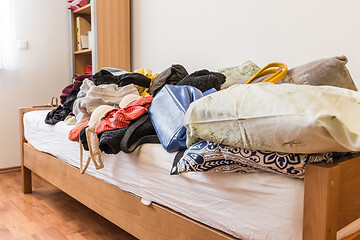 Image showing Messy teenager room. Untidy cluttered bed,  dirty clothes.