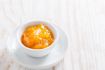 Image showing Lemon curd or fruit jelly in small bowl on wooden background